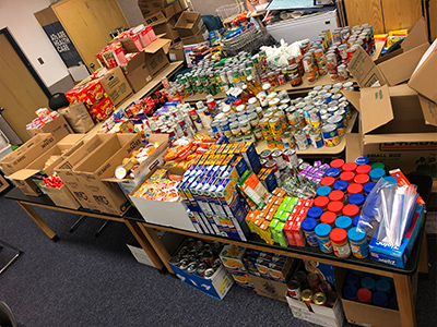 Photo showing a room full of tables filled with donated food items